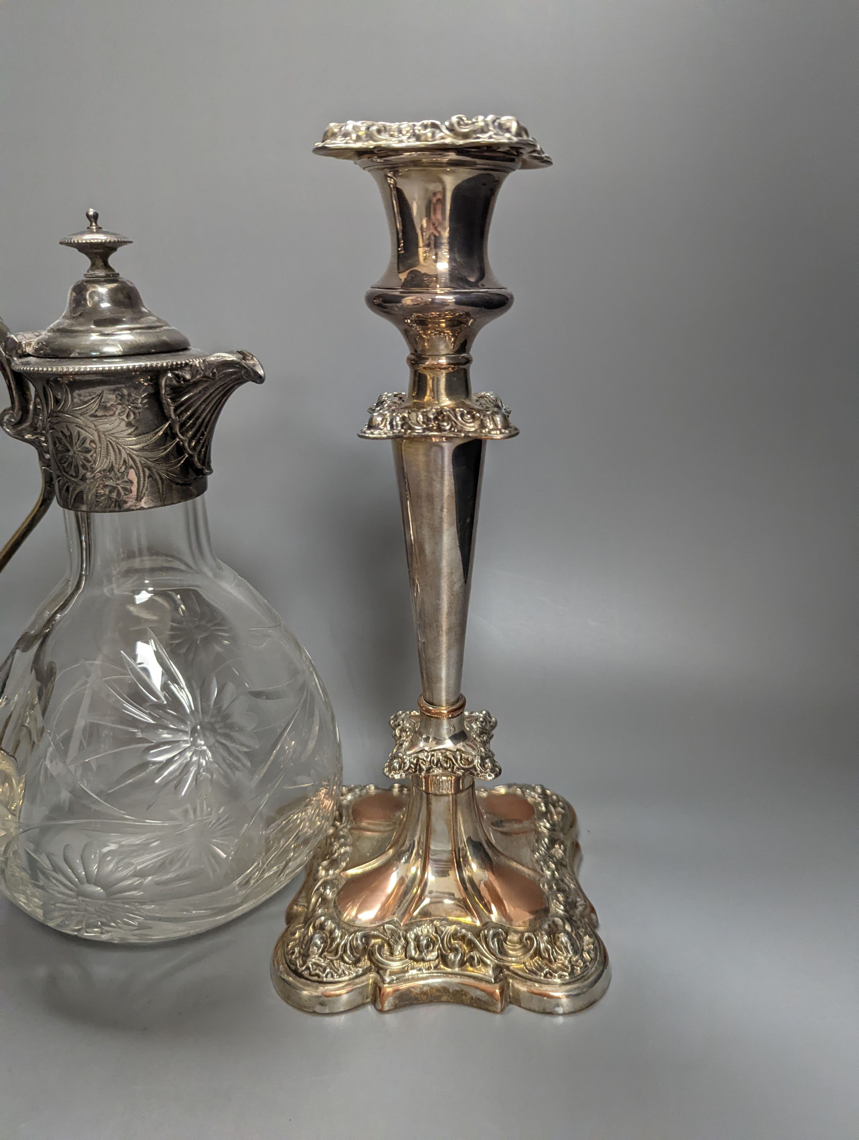 A Victorian electroplate mounted glass Claret jug, 23.5cm high and a pair of candlesticks